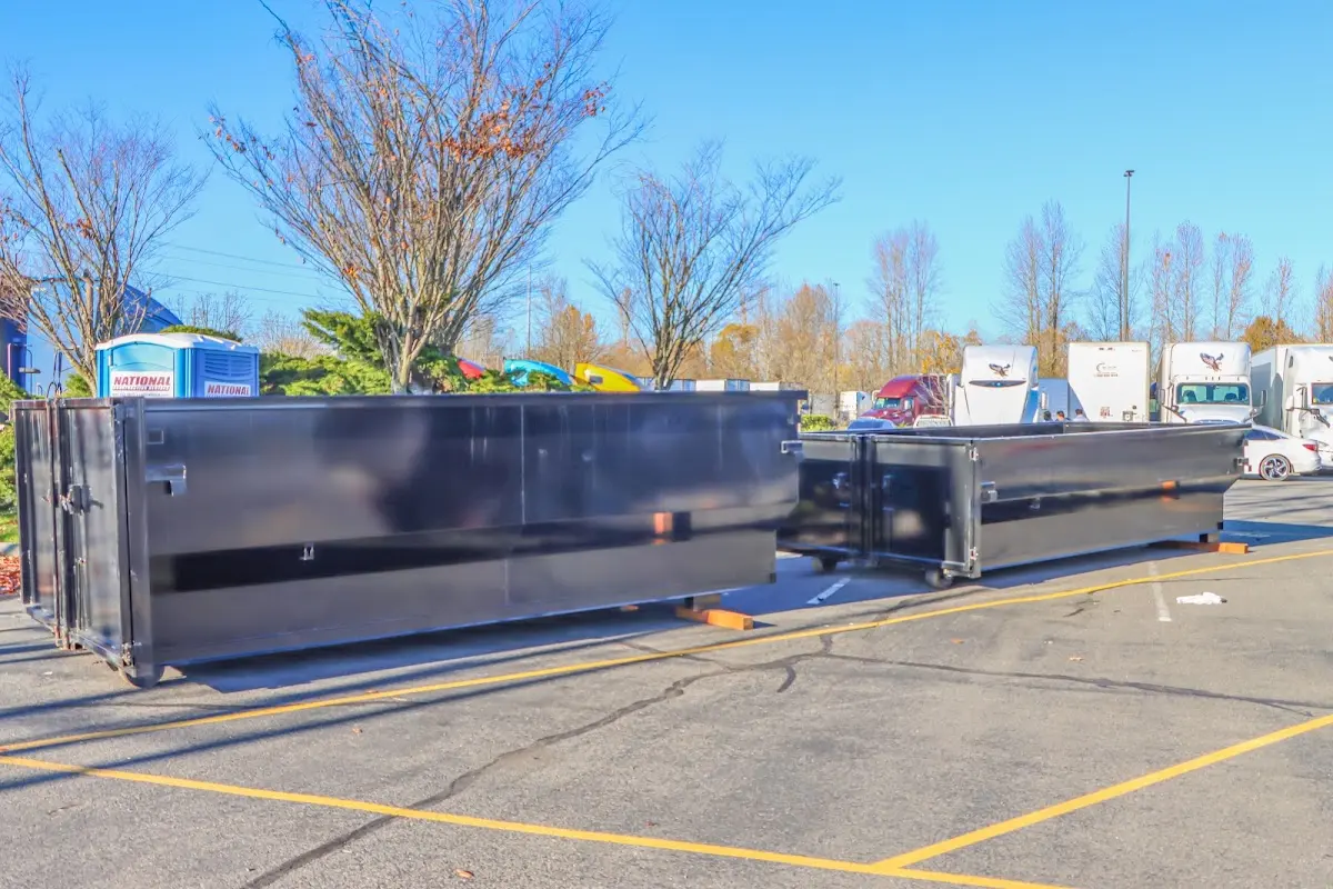 Professional dumpster rental service with roll-off container on residential driveway in East Earl